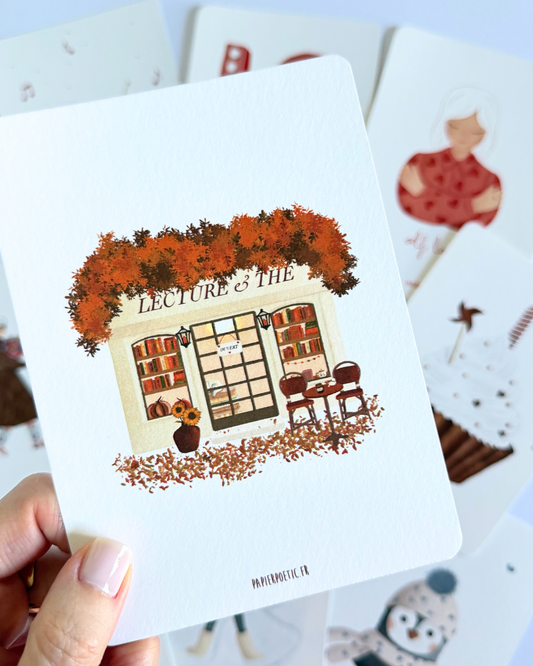 A square art print featuring an illustration of a cozy bookshop storefront labeled 'LECTURE & THE BOOKS' with autumn orange foliage, brown chairs, and scattered leaves on a white background.