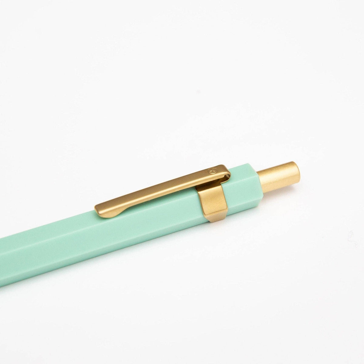 Mint green pen with gold clip on a white background