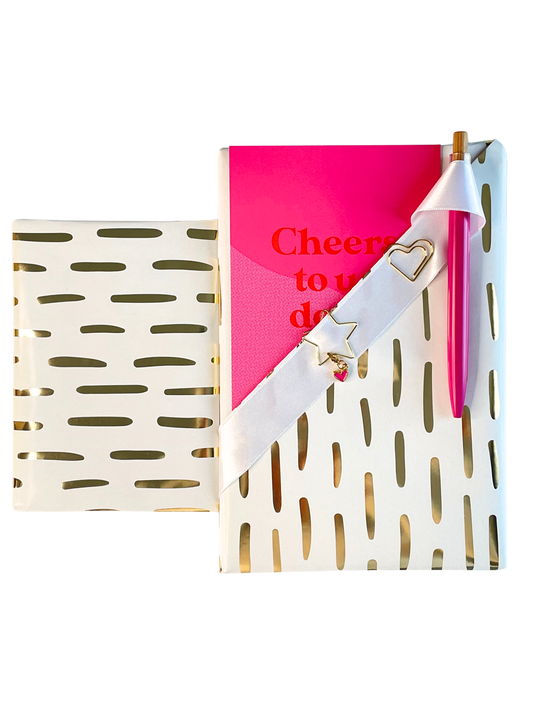 Pink notebook, floral sticker book, and pink card with 'Cheers to us dear' text on a white background.