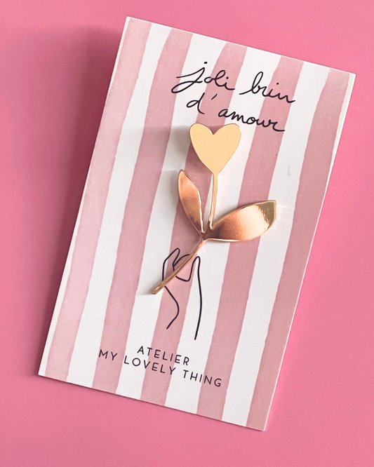 Notebook with gold accents, pink pen, and decorative items on a white background