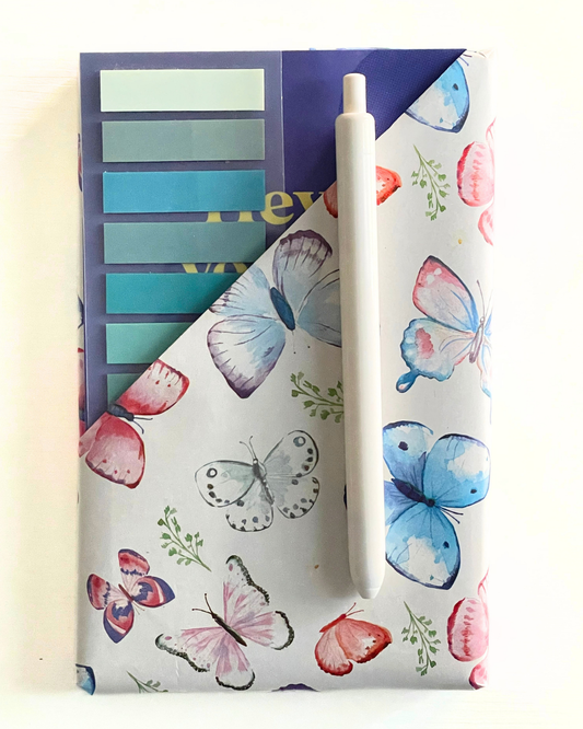 Notebook with blue and beige striped cover titled 'Everyday Lists' on a beige fabric background.
