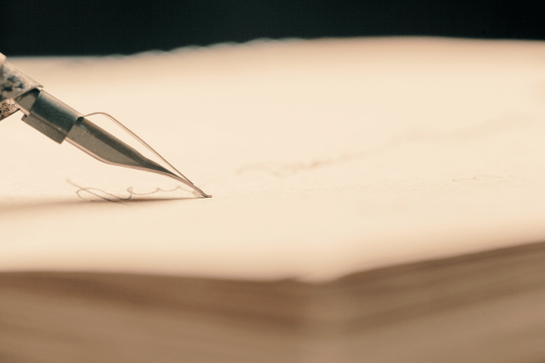 pen writing on a notebook