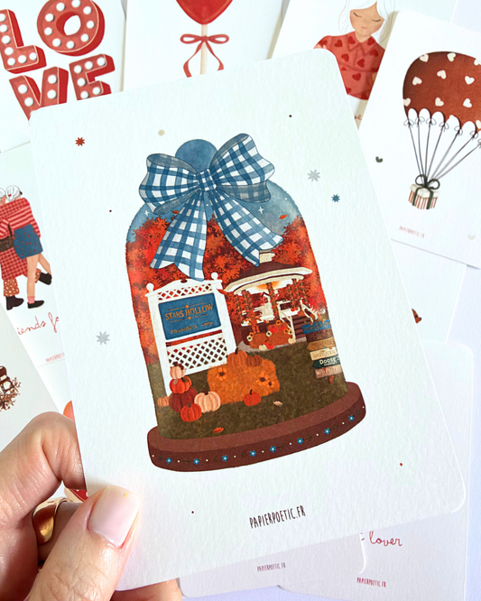 A rectangular art print or card featuring an illustrated autumn scene inside a glass dome with a blue-and-white gingham bow. The scene includes orange and red fall leaves, a carousel, a small building, and pumpkins on a brown base, set against a white background with small scattered star-like dots.