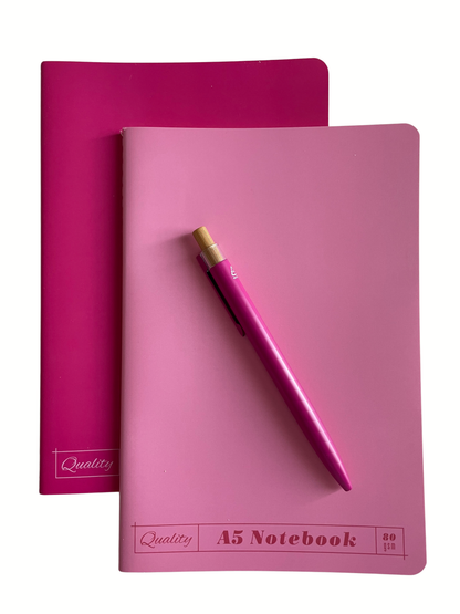 Pink A5 notebook with a pink pen on a white background