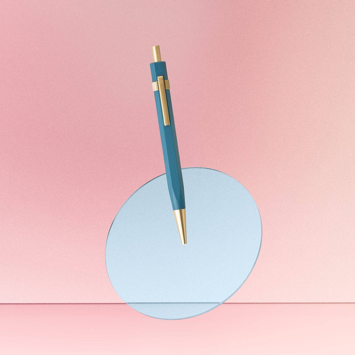 Blue pen with gold accents on a pink background