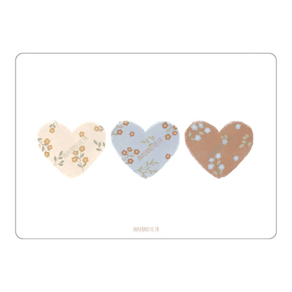 Three heart-shaped stickers with floral designs on a white background