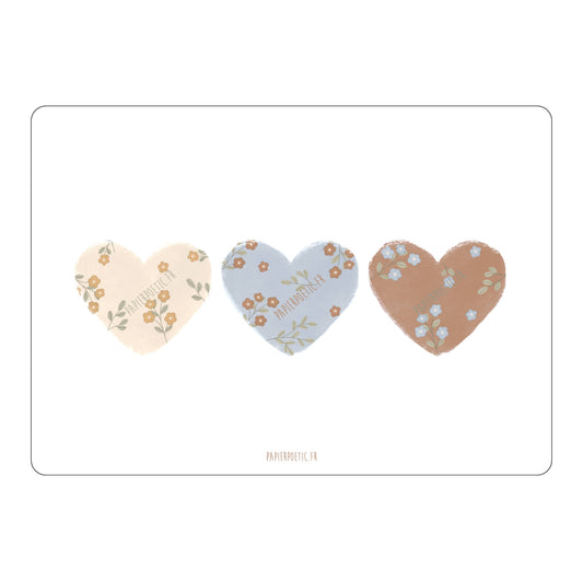 Three heart-shaped stickers with floral designs on a white background