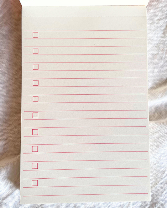 A card deck or notebook titled 'EVERYDAY LISTS' with a coral-red, blue, and cream floral pattern, wrapped with a white paper band that reads 'In ink and paper, out of my head.' on a white background.