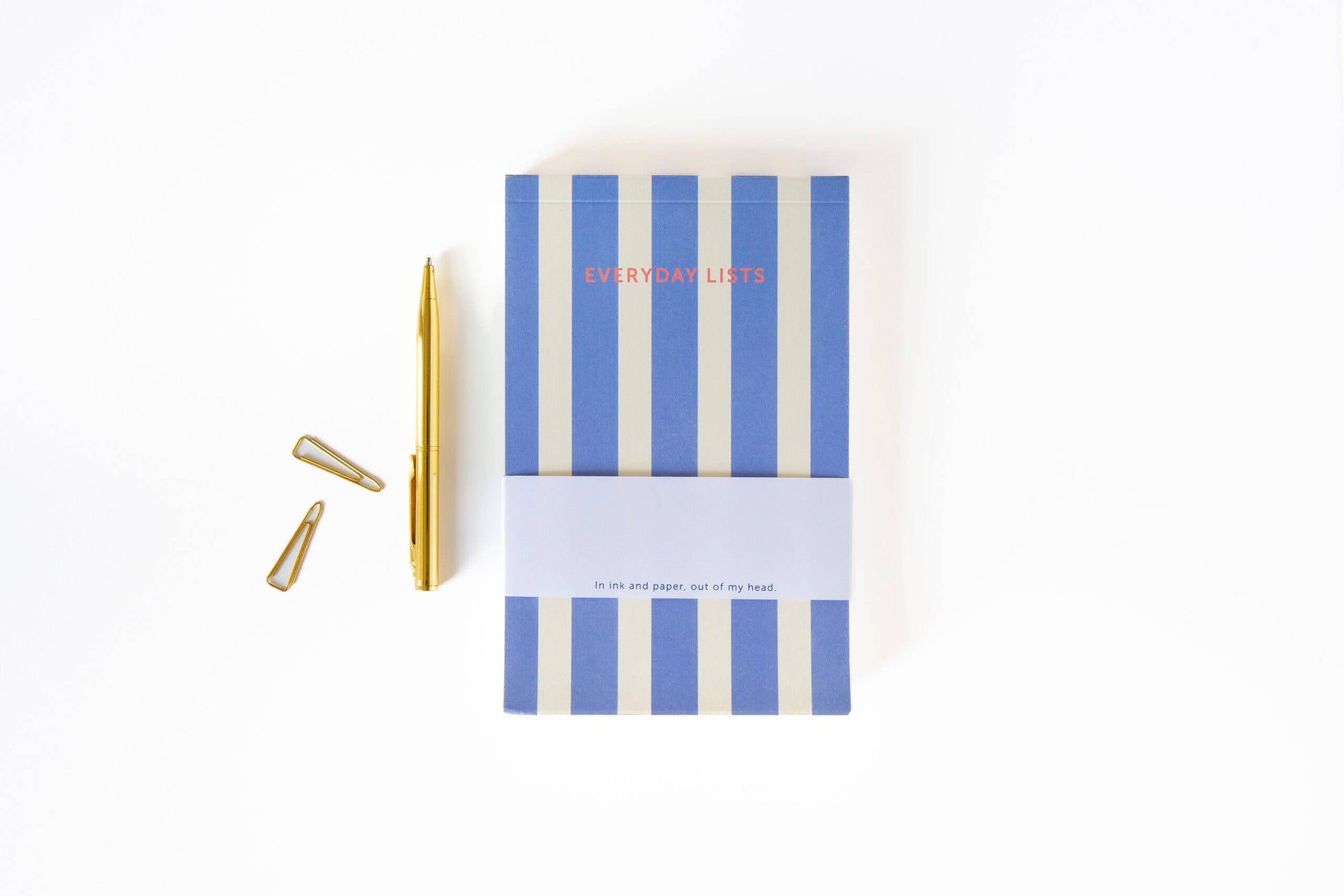 Notebook with blue and white striped cover and gold pen on a white background