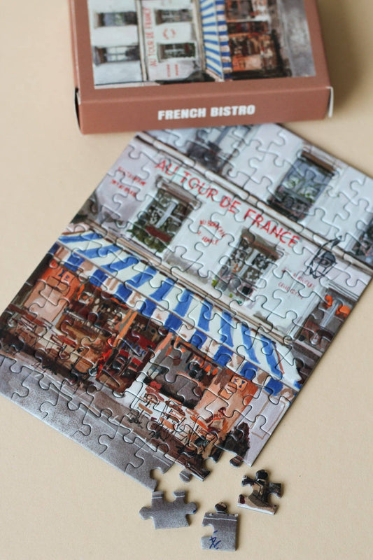 Product packaging with a scenic image of a French bistro on a clear background