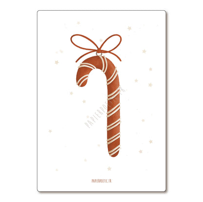 A vertical rectangular print or card featuring a stylized brown candy cane with white stripes and a brown bow, centered on a white background with faint small star motifs. The text 'PAPIERMOYEC.