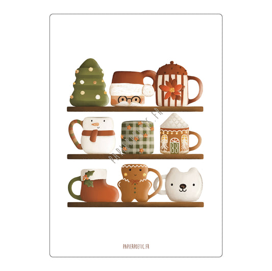 A framed art print featuring a whimsical illustration of three shelves filled with cozy holiday-themed mugs and cups, including a Christmas tree mug, a snowman mug, a gingerbread house mug, and a bear mug. The print has a white border with the text 'PAPIERMOYE.