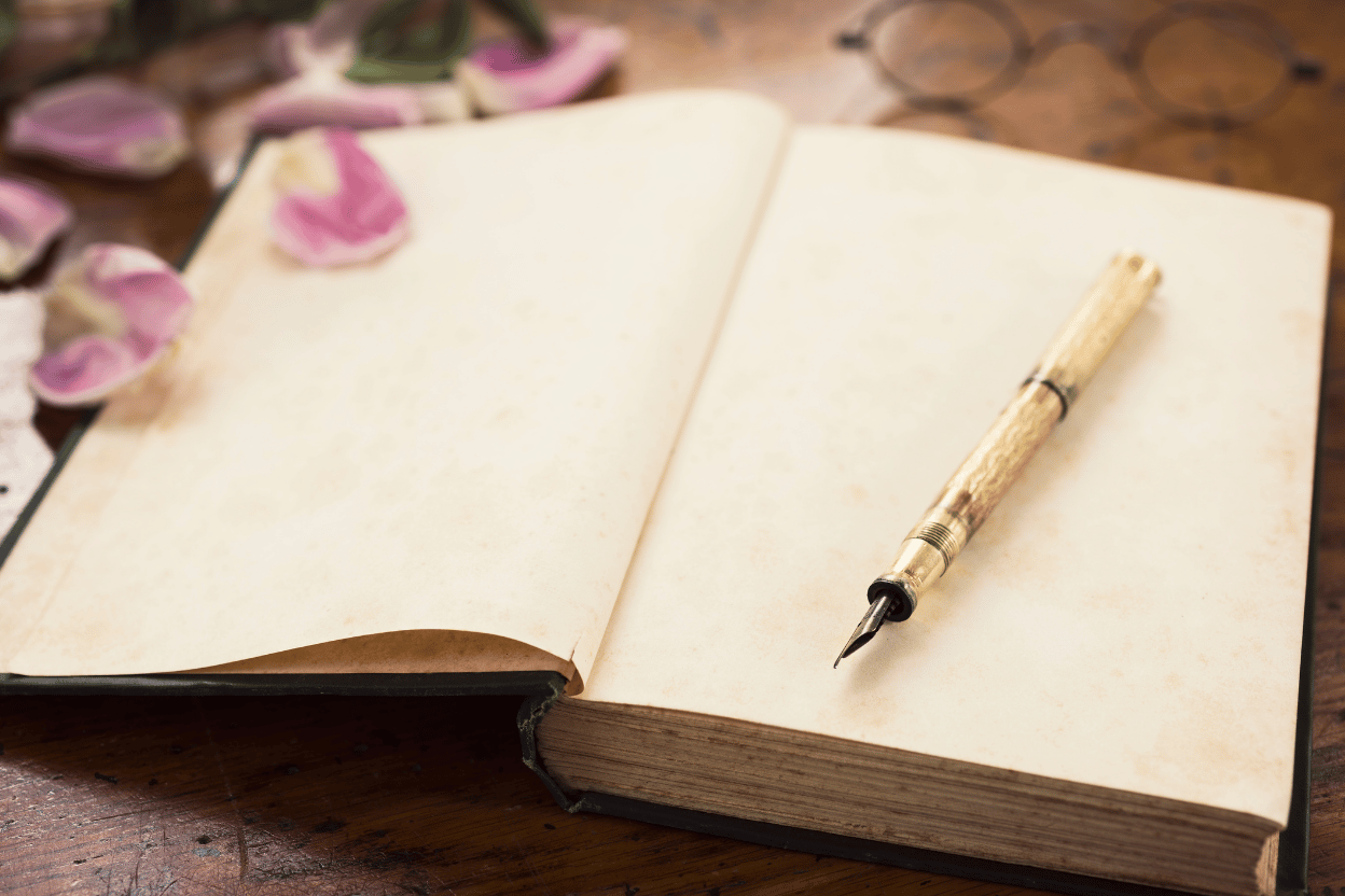 Open notebook with a wooden pen on a wooden surface for journaling