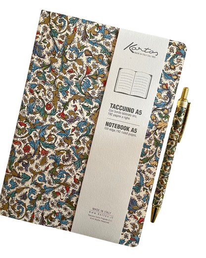 A Kento notebook with an ornate multicolor floral and scroll pattern on a cream background, shown with a white paper sleeve and a matching gold pen on a clean white background.