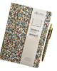A Kento notebook with an ornate multicolor floral and scroll pattern on a cream background, shown with a white paper sleeve and a matching gold pen on a clean white background.