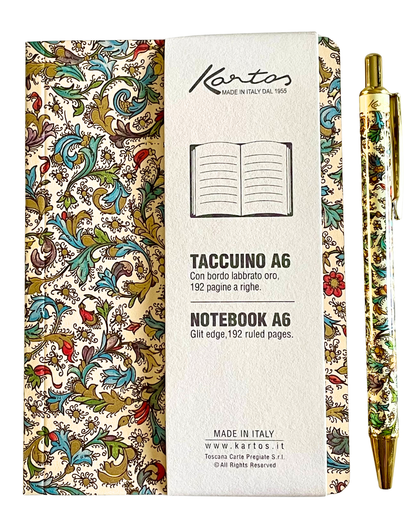 A Kottos A6 notebook with a cream-colored cover featuring a vintage botanical and bird pattern, shown next to its white paper sleeve and a matching gold pen with the same pattern.