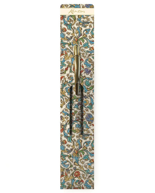 A Kento notebook with an ornate multicolor floral and scroll pattern on a cream background, shown with a white paper sleeve and a matching gold pen on a clean white background.