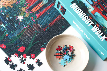 Puzzle with pieces and box titled 'Midnight Walk' on a table.