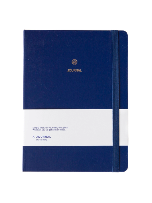 A navy blue hardcover journal with a white lower band, gold foil logo and the word 'JOURNAL' on the cover, shown standing upright against a white background.