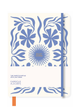 A notebook with a cream-colored cover featuring a blue floral and leaf pattern, a blue elastic closure band, and a small orange bookmark tab at the bottom left. The cover includes the text 'I am ready to soak up all of your ideas.