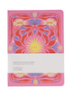 A pink Fabrique & La Carte notebook with a colorful floral pattern on the cover, wrapped in a white paper band.