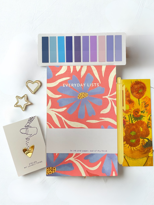 Color swatch book, notebooks with floral designs, and decorative items on a white background