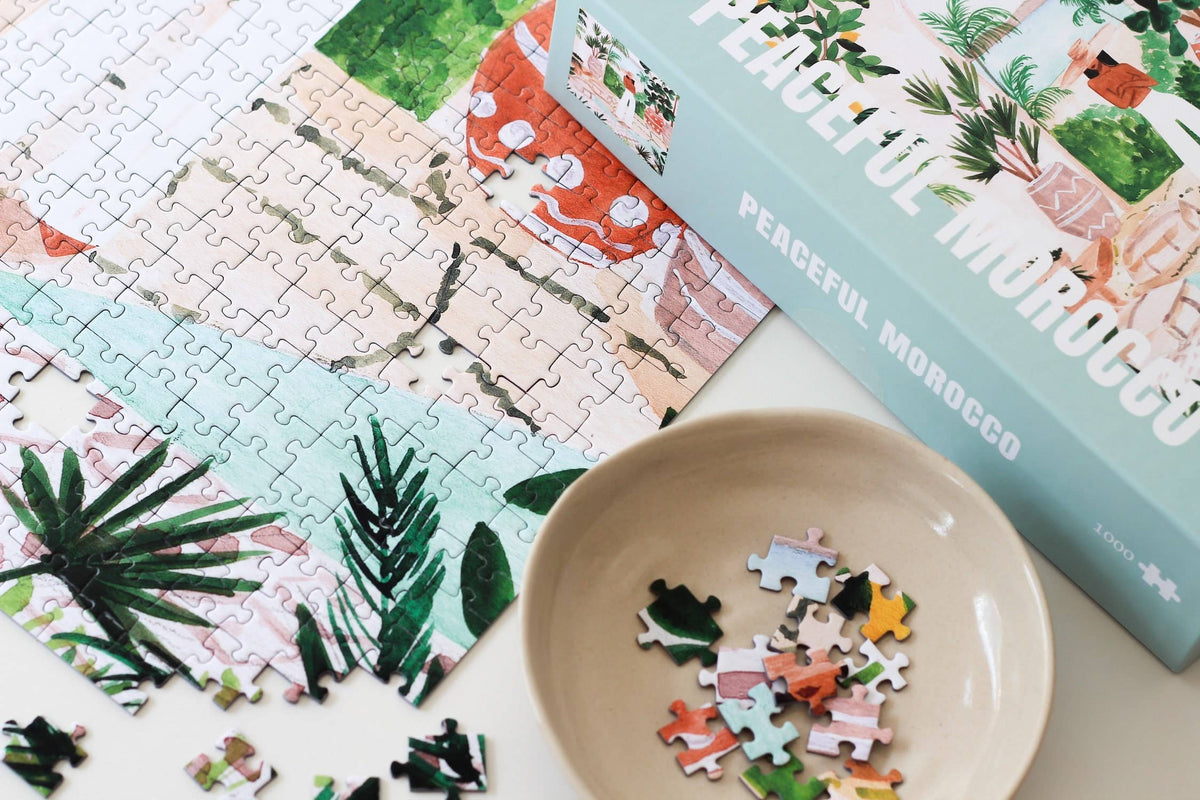Jigsaw puzzle with 'Peaceful Morocco' theme, partially completed, on a white surface.