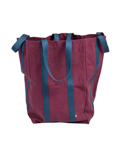 A large canvas tote bag in burgundy with dark teal-blue handles and side trim, shown against a plain white background.