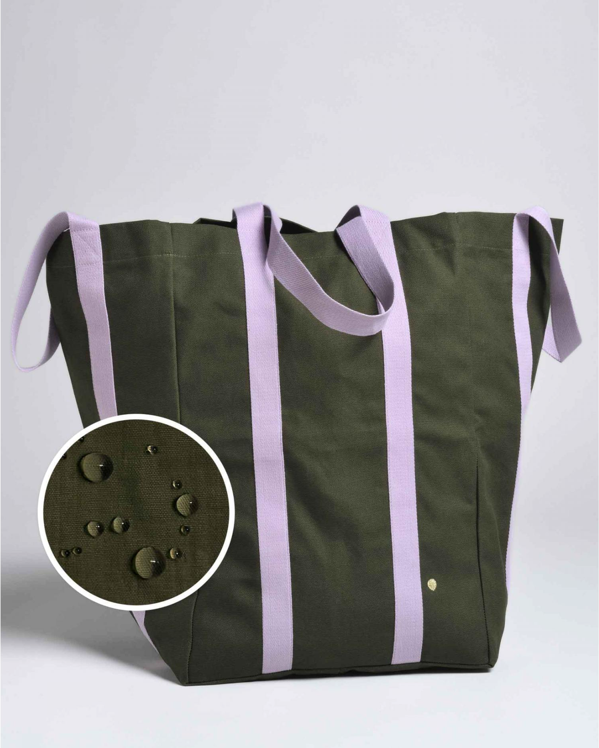 An olive green canvas tote bag with lavender purple straps, featuring a circular inset detail showing water droplets on the surface.