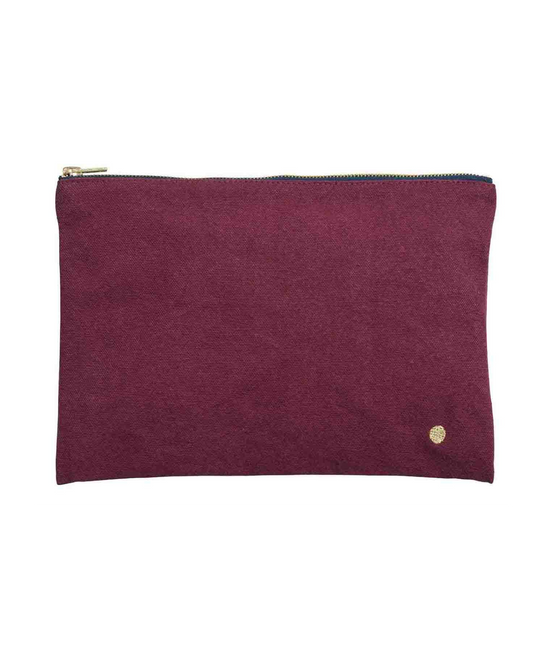 A rectangular zippered pouch in textured magenta suede with a gold zipper and a small gold logo emblem on the bottom right, set against a plain white background.