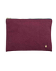 A rectangular zippered pouch in textured magenta suede with a gold zipper and a small gold logo emblem on the bottom right, set against a plain white background.