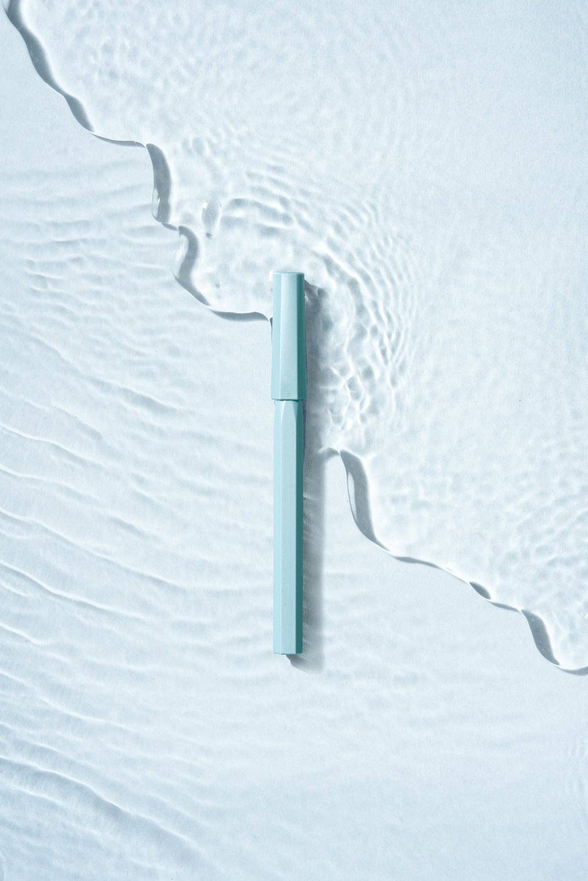 Light blue pen on a textured white surface