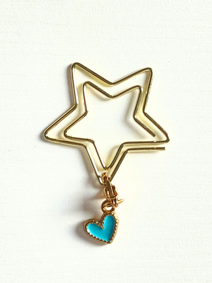 Gold star-shaped keychain with a turquoise heart charm on a white background