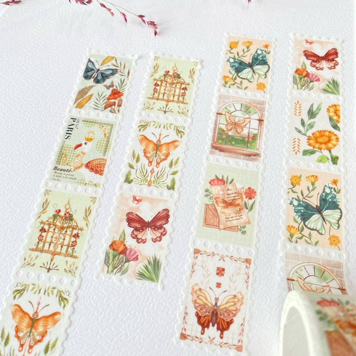 Three rolls of decorative washi tape featuring vintage-style botanical and butterfly illustrations, arranged on a textured white surface.