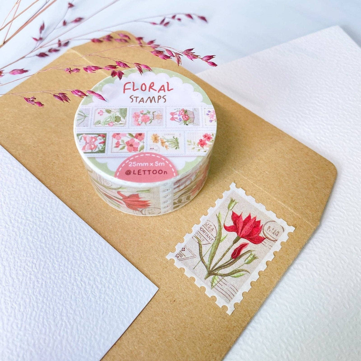 Container of floral stamps with a single stamp on kraft paper