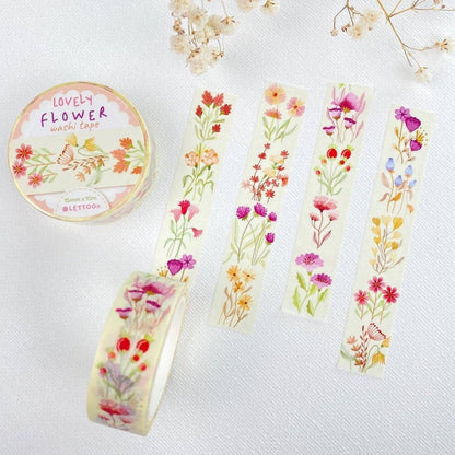 A roll of decorative washi tape labeled 'Lovely Flower washi tape' is shown beside several flat strips of the same tape featuring colorful watercolor-style floral prints on a white textured background.