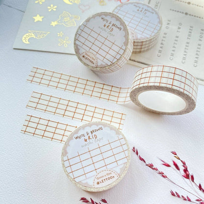 Three rolls of washi tape with a white and brown grid pattern are arranged on a textured white surface alongside matching strips and decorative gold foil paper. The labels on the rolls read 'WHITE & BROWN GRID washi tape' and show the brand 'Lettoo'.