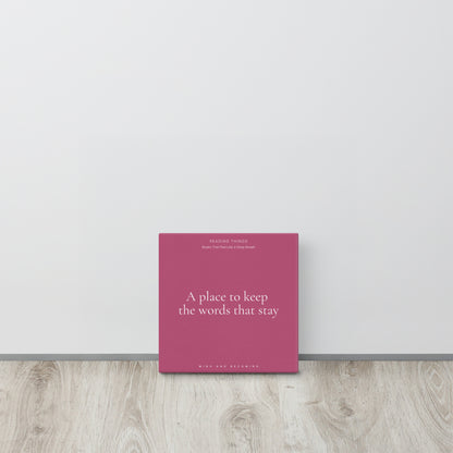 Pink book titled 'A place to keep the words that stay' on a light wooden surface with a white wall background.