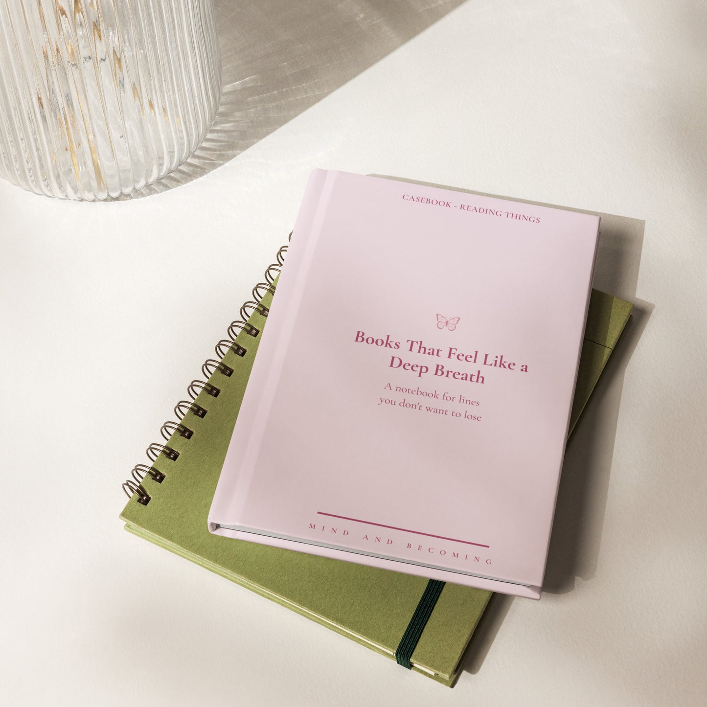 Pink notebook titled 'Books That Feel Like a Deep Breath' on a green notebook with a white background.