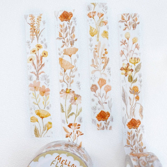 Four vertical strips of floral washi tape with a watercolor-style botanical pattern in muted orange, yellow, peach, and soft green on a white background. A roll of matching tape is partially visible at the bottom.