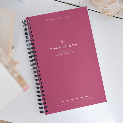 Pink notebook with text on a white surface