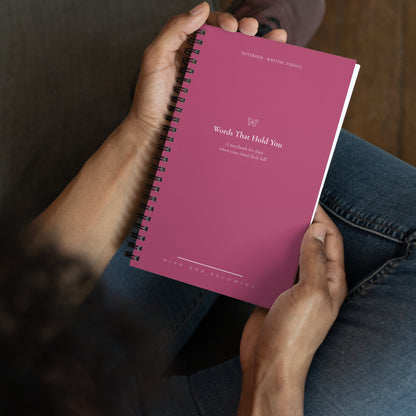 Person holding a pink notebook with text on the cover