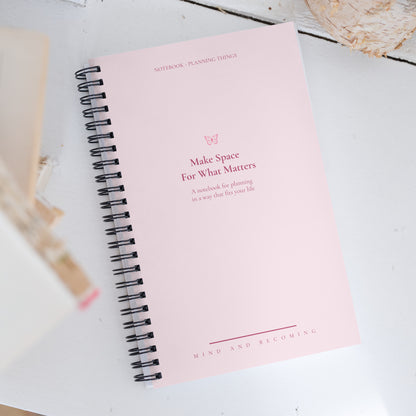 Pink notebook with text on a white surface