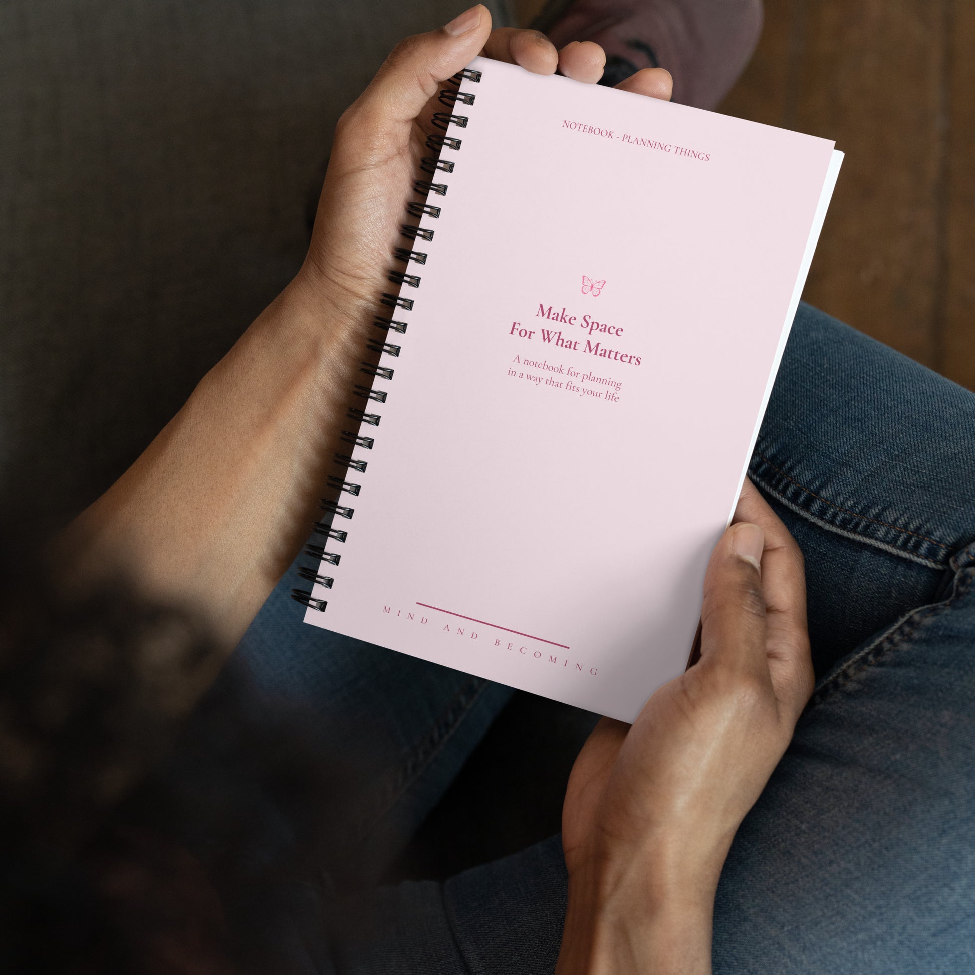 Person holding a pink planner with text on the cover