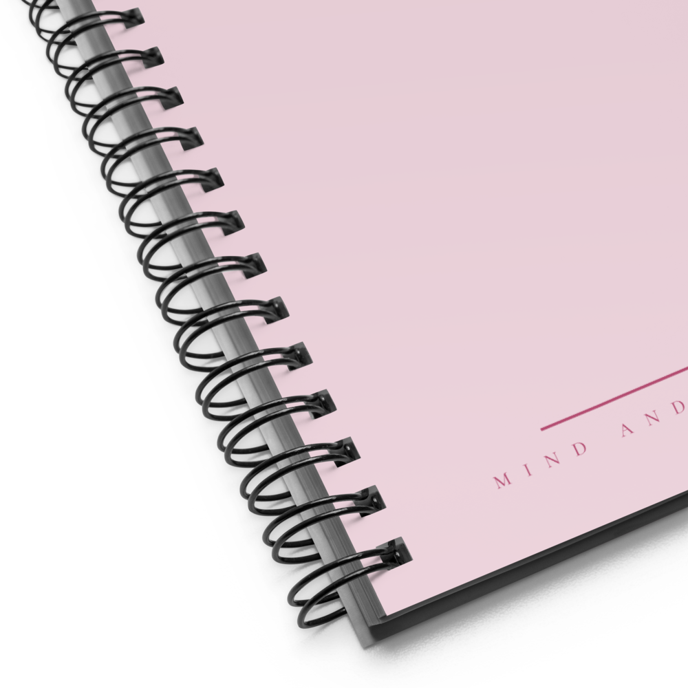 Spiral-bound notebook with a pink cover and 'MIND AND' text.