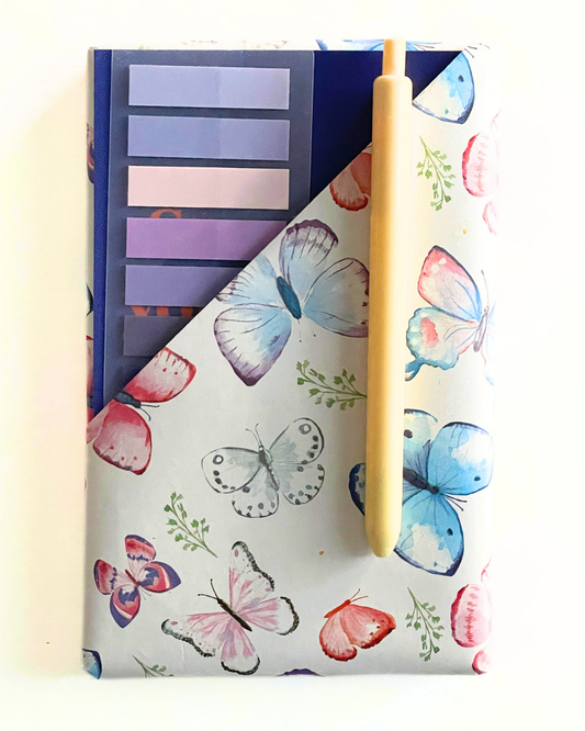 Notebook with floral design and 'Everyday Lists' text, surrounded by decorative clips on a light background.